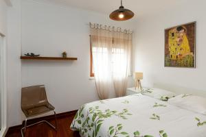 a bedroom with a bed and a chair and a window at Sintra 23 in Sintra