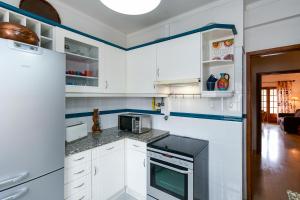 a kitchen with white cabinets and a stove top oven at Sintra 23 in Sintra