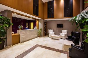 a lobby with two chairs and a reception desk at City's Hill Hotel in Kuşadası