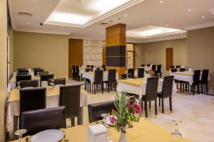 a dining room with tables and chairs and tablesktop at City's Hill Hotel in Kuşadası