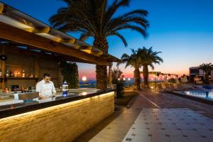 a man standing at a bar at a resort at City's Hill Hotel in Kuşadası
