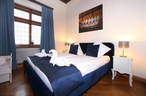 Un dormitorio con una cama grande con dos cisnes blancos. en Schloss Fischhorn am See, en Bruck an der Großglocknerstraße