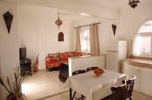 een woonkamer met een tafel en een bank bij Dar Océana in Tamraght Ou Fella