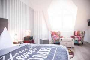 a bedroom with a bed and two chairs and a window at Hotel Wulff in Bad Sassendorf