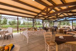 een eetkamer met tafels en stoelen en een eettafel bij Villa Marina Velca in Porto Clementino