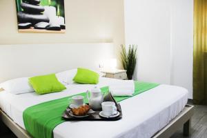 Una cama blanca con una bandeja de comida. en Hotel Cesirja, en Casavatore