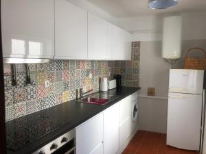 a kitchen with white cabinets and a white refrigerator at Central Tavira apartment, Casa Oliverio in Tavira +22 photos