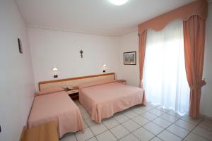 a bedroom with two beds and a window at Albergo San Michele in San Giovanni Rotondo