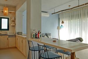 eine Küche mit einem Holztisch, Stühlen und einer Theke in der Unterkunft Villa Melani in Mytilini