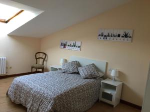 - une chambre avec un lit et deux photos sur le mur dans l'établissement EMILIA -Claudio Moyano, à Valladolid