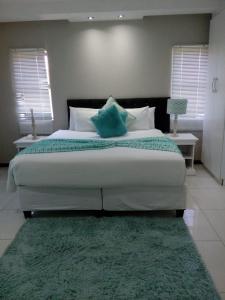 um quarto com uma cama grande e um tapete verde em Shoes Guest House em Mthatha