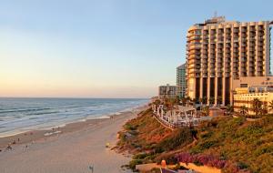 a view of a beach with a hotel and the ocean at Raphael Apartments in Herzliya