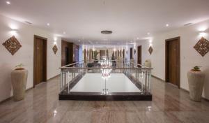 um átrio com uma escada de vidro num edifício em Sapphire Premium Hotel & Suite em Karād