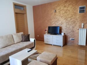 a living room with a couch and a tv at Apartman KEJ free parking in Kraljevo