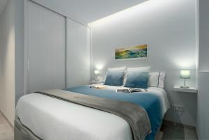 een slaapkamer met een groot bed met blauwe lakens bij Frontline with Blue Views in Las Palmas de Gran Canaria