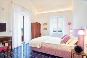 a bedroom with a bed and a desk and a television at Palazzo Gentilcore in Castellabate