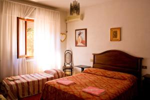 a bedroom with two beds and a window at Morianese Residence in Lucca