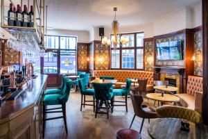 a restaurant with tables and chairs and a bar at Three Falcons in London