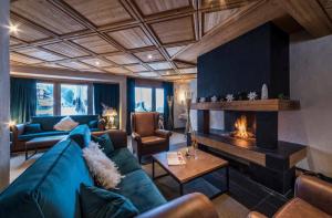 a living room with a blue couch and a fireplace at Hotel Maya Caprice in Wengen