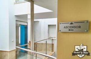 a sign on a wall next to a staircase in a building at Hostal Restaurante La Niña in Palos de la Frontera