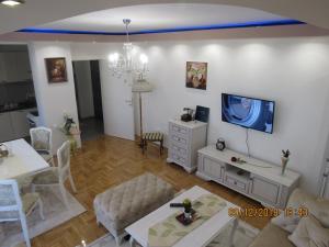 a living room with a couch and a tv on a wall at Apartman Tea 2 in Banja Luka
