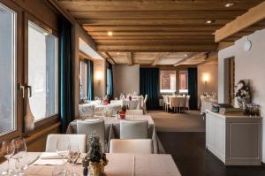 un ristorante con tavoli bianchi e sedie bianche di Hotel Maya Caprice a Wengen