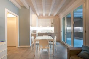eine Küche und ein Esszimmer mit einem Tisch und Stühlen in der Unterkunft Residence Fornaci in Peschiera del Garda