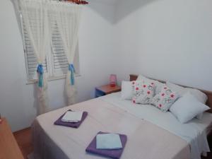 a bedroom with a white bed with towels on it at Apartman Radic in Ston
