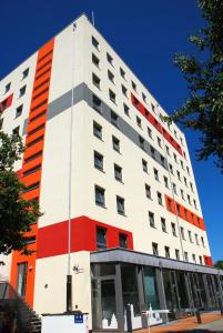 a tall building with red and white at Ausbildungshotel St. Theresia in Munich