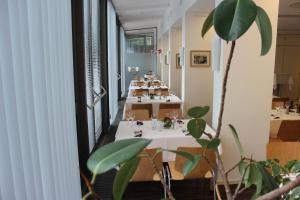 a dining room with white tables and a plant at Ausbildungshotel St. Theresia in Munich