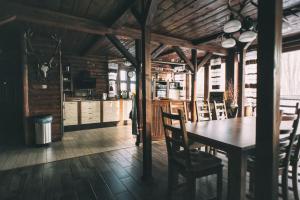 a dining room with a wooden table and chairs at Gasan Place - Domki na Mazurach in Pisz