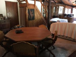Cette chambre comprend une table et des chaises en bois. dans l'établissement Toad Tree Cabins, à Sodwana Bay