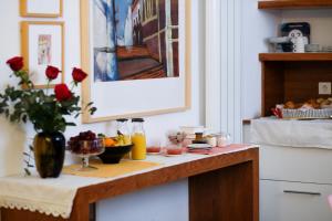 a kitchen counter with a table with food and flowers at Hostal Casa Limon in Sanlúcar de Barrameda