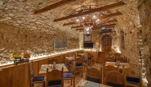 un restaurant avec un mur en pierre, des tables et des chaises dans l'établissement KAMARES Historic Boutique Hotel & Spa, à Ioannina