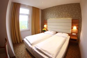 a bedroom with a large bed and a window at Schlosshotel Molkenkur in Heidelberg