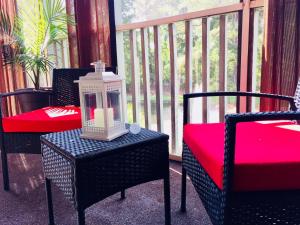 a porch with chairs and a table with a lantern at Southern Sophistication at the Park in Charleston