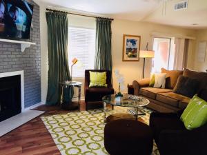a living room with a couch and a fireplace at Southern Sophistication at the Park in Charleston
