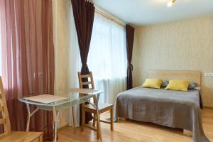 トムスクにある"GOOD NIGHT" on Nikitina 17aのベッドルーム1室(ベッド1台、テーブル、窓付)