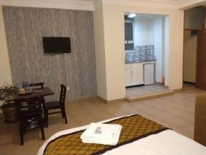 a hotel room with a bed and a table and a kitchen at Mekelle Hotel in Mekʼelē