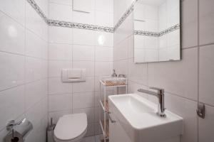 biała łazienka z umywalką i toaletą w obiekcie LAAX Homes - Capolgarten 3,7 w mieście Flims