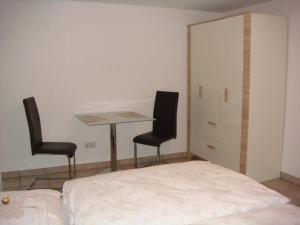 1 dormitorio con 1 cama, 1 mesa y 2 sillas en Ferienwohnung Thimm en Bad Krozingen