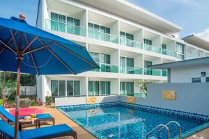 a hotel with a swimming pool and an umbrella at The Tree Samui in Bophut 