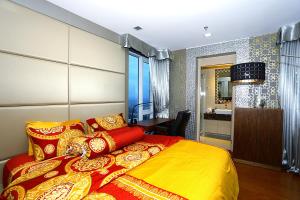 a bedroom with a bed with a yellow and red blanket at Lux SL Luxury Style of Life 5 in North Pattaya