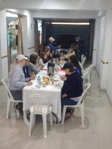 a group of people sitting at a table eating at Imperio Tanpu Q in Lima