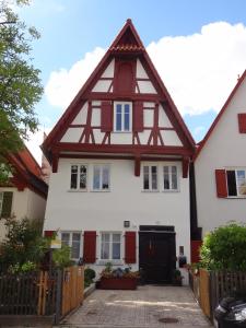 a white house with a gambrel roof at Ferienwohnung Eulenloch in Nördlingen
