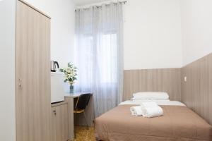 a bedroom with a bed and a desk and a window at Affittacamere San Martino in Genoa