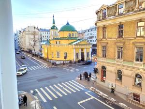 a view of a city street with a yellow building at Brivibas Center Apartments in Riga