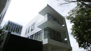 a large white building with glass windows at The Dahlias at Afamosa Melaka in Kampong Batang Melekek