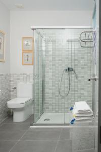 a bathroom with a glass shower and a toilet at Casa Limon in Sanlúcar de Barrameda