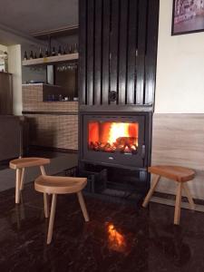 a fireplace with two chairs in front of it at Hotel Millenium2 in Prizren